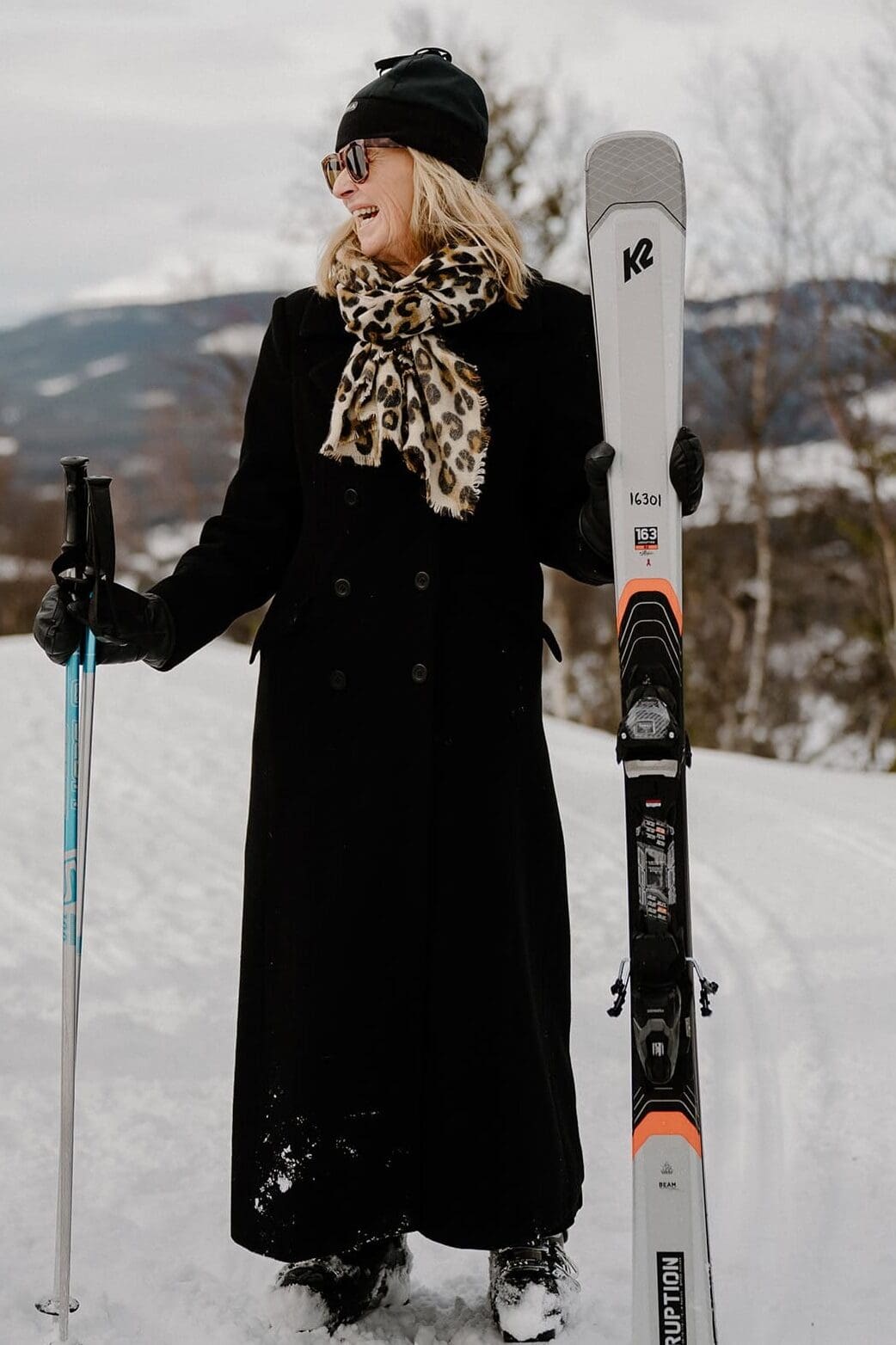 Glad bröllopsgäst håller i sina skidor.